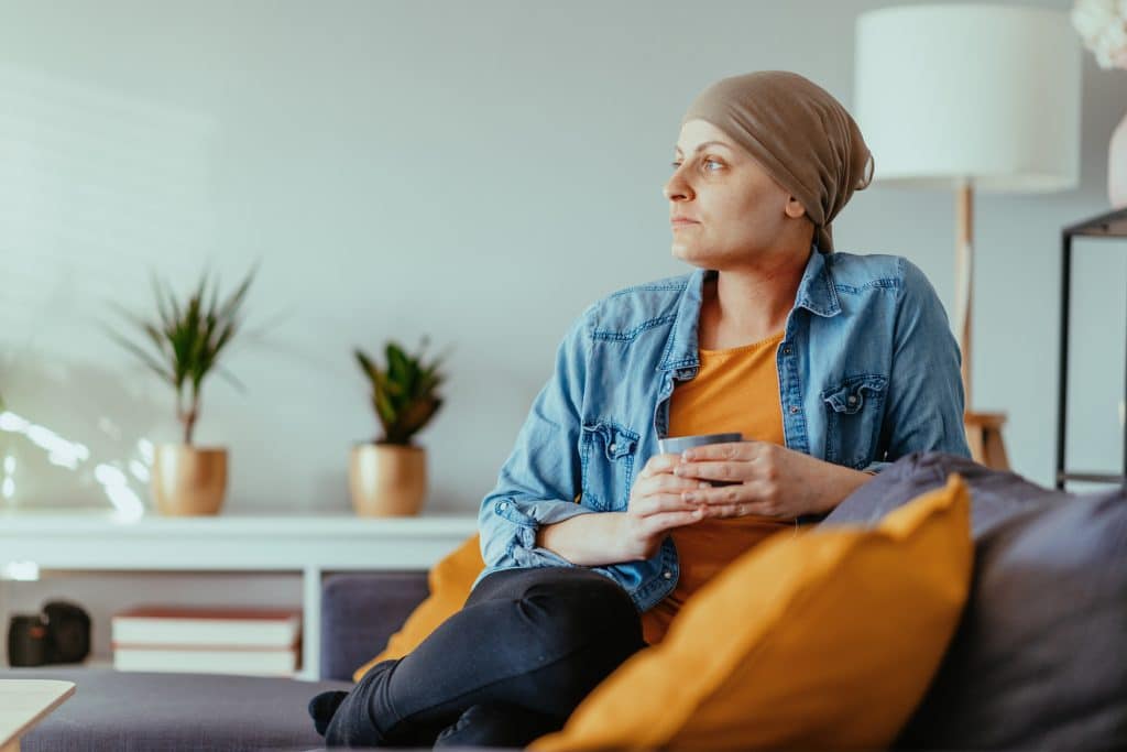 A woman sits in her home in Los Angeles wondering if her cancer symptoms qualify her for Social Security.