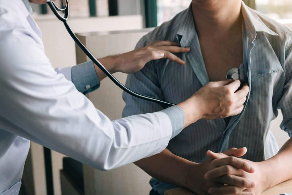 Doctor examining sick male patient