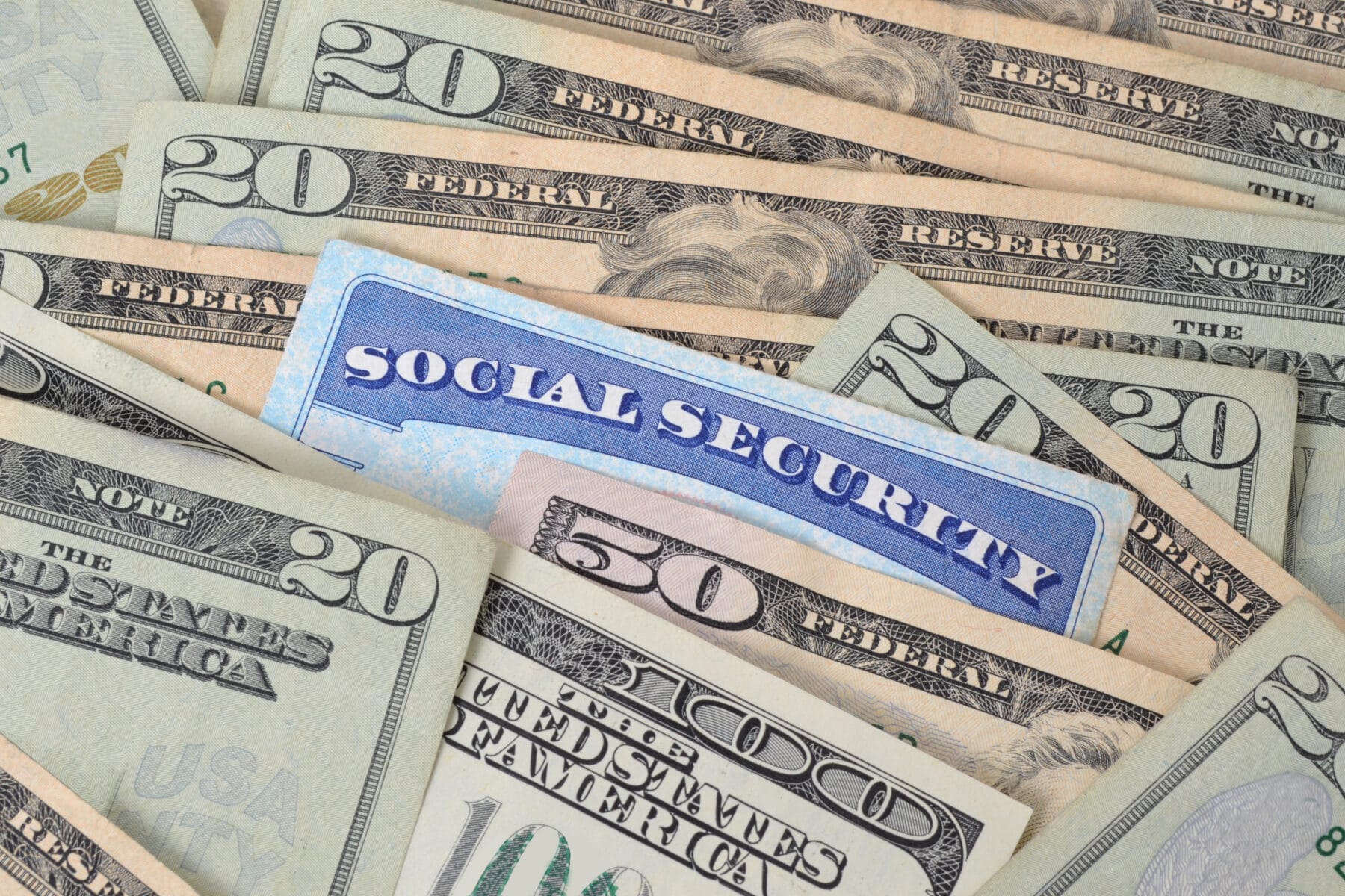 A Social Security card surrounded by dollar bills of various amounts.