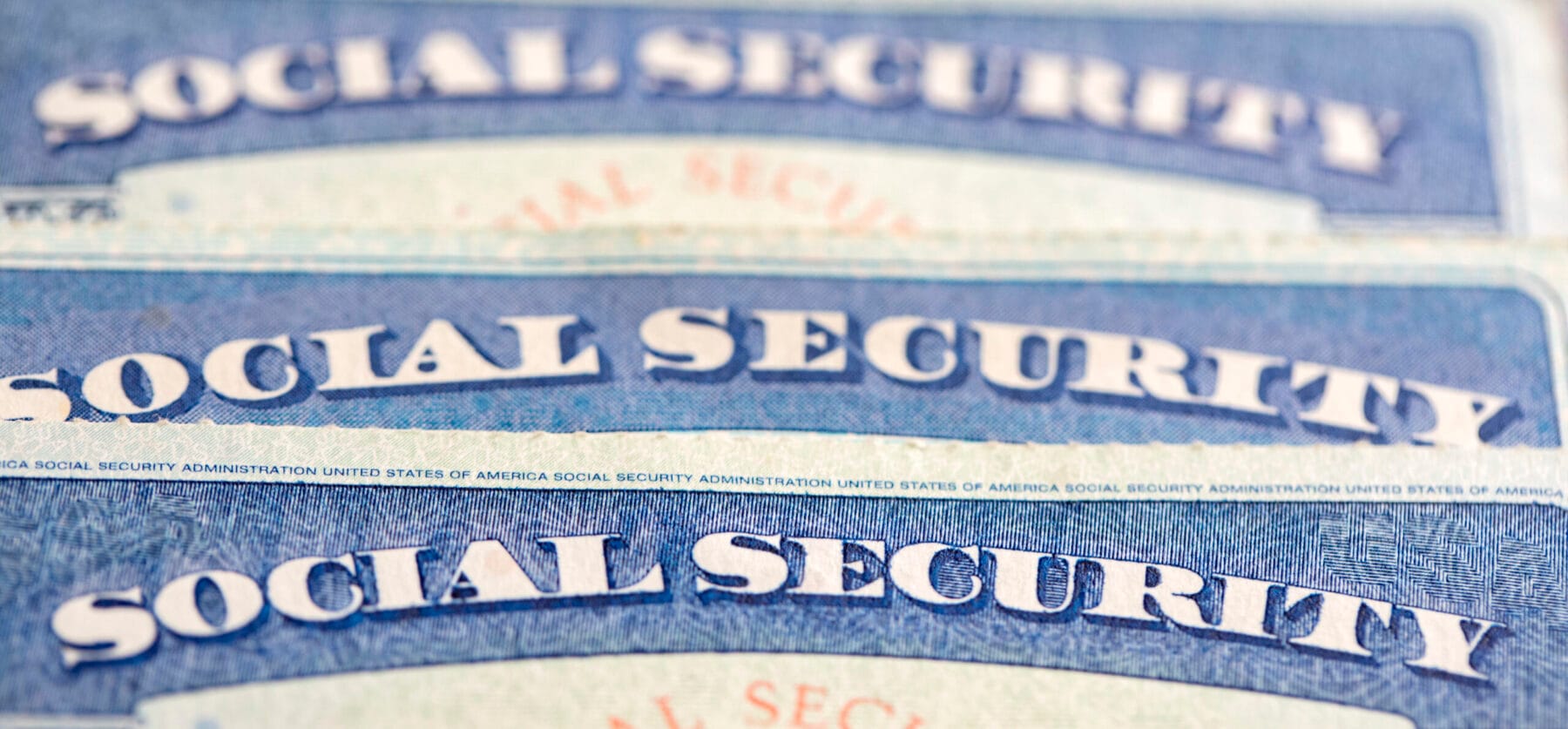 Close-up of four Social Security cards stacked on top of each other.
